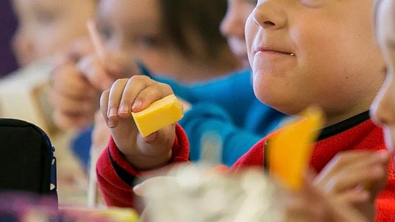 image of a younger individual eating a block of cheese