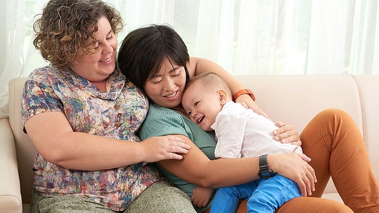 image of individuals sitting and cuddling while holding a baby