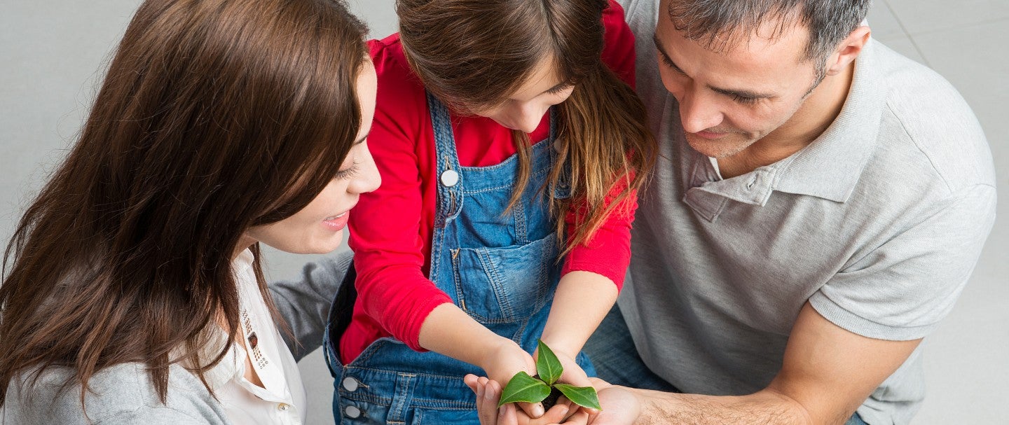 Family holding a plant