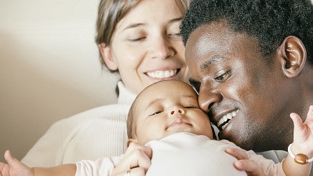 Two parents cuddle a baby