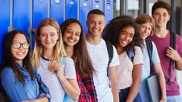 image of young individuals looking towards camera while leaning against lockers