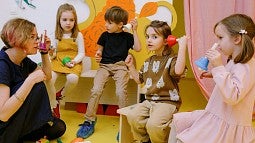image of children in a classroom setting doing an activity with a teacher