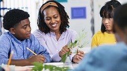 individual sitting at table talking to students