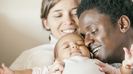 Two parents cuddle a baby Two parents cuddle a baby