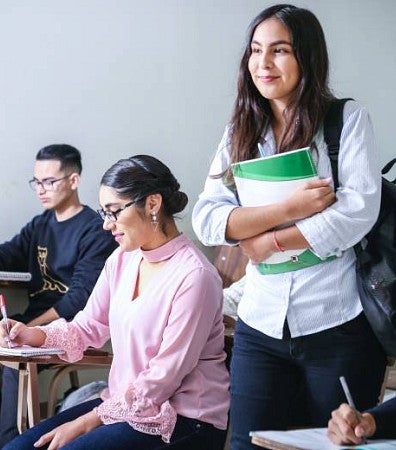 Woman carrying white and green textbook